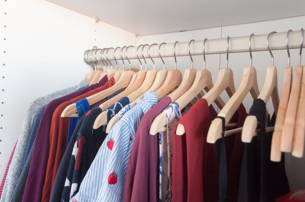 A picture of several clothing items hanging in a closet